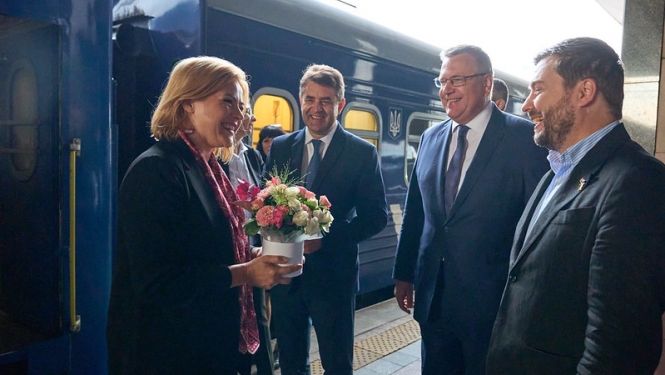 Ministru prezidente Evika Siliņa Kijivā. Ministru prezidenti sagaida amatpersonas.  Fonā vilciens. 