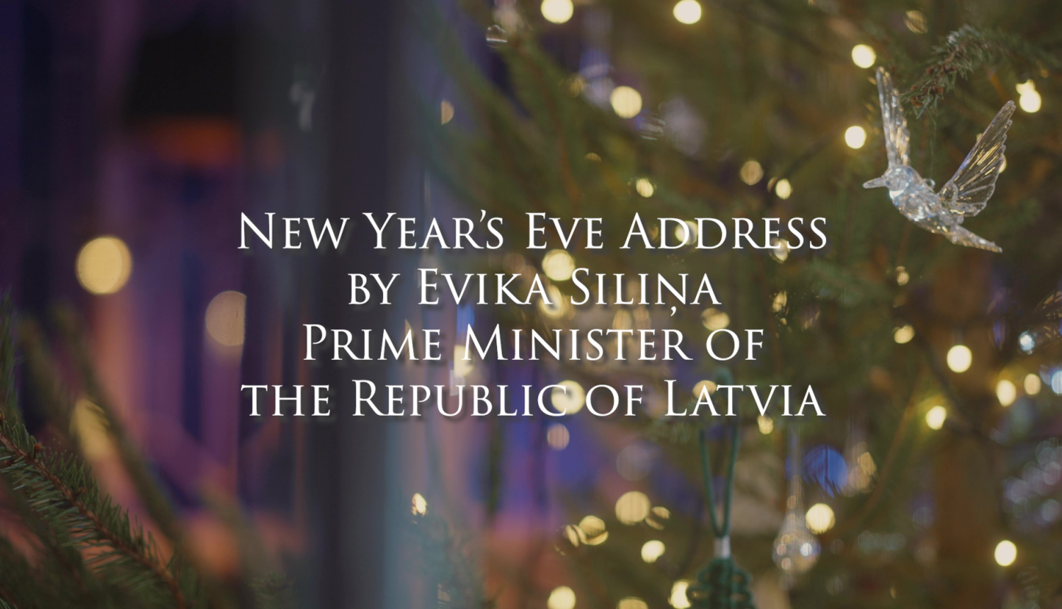 Text New Year's Eve Address by Evika Siliņa Prime Minister of the Republic of Latvia, lights in the branches of a Christmas tree in the background