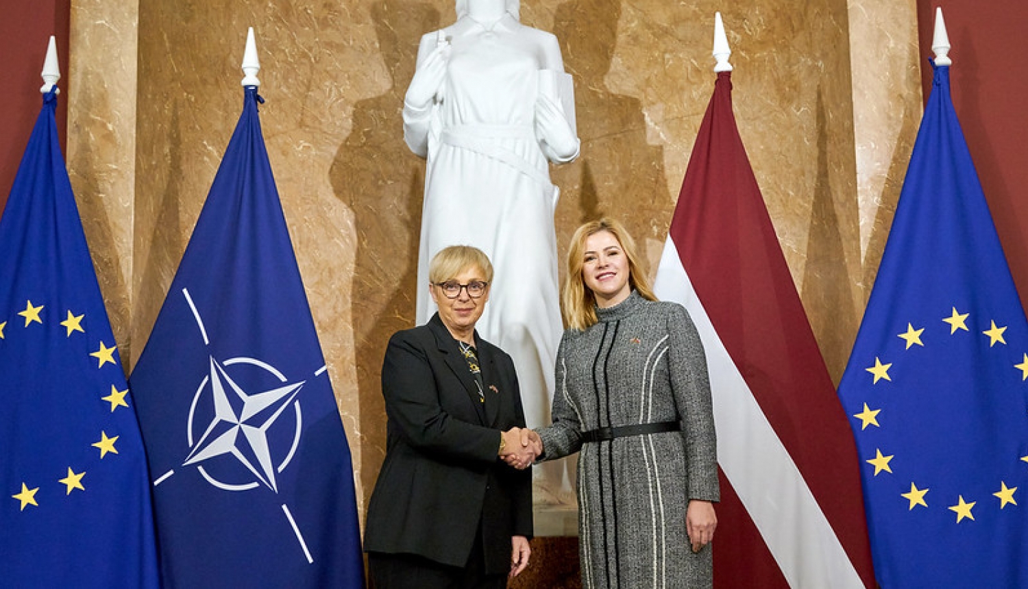 Ministru prezidente Evika Siliņa sasveicinās ar Slovēnijas prezidenti Natašu Pircu Musaru. Abas amatpersonas stāv 1.stāva vestibilā Ministru kabinetā. fonā ES,NATO, Latvijas karogi. 